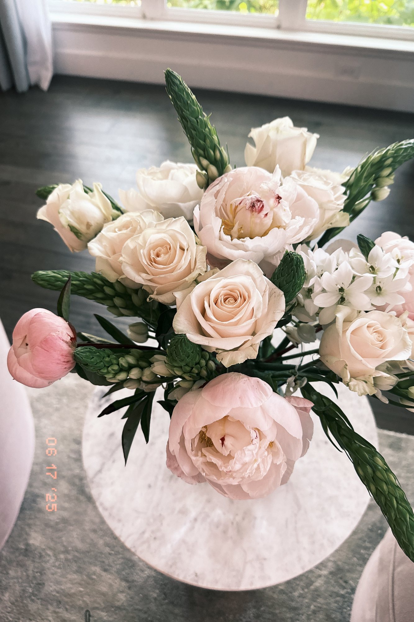 Blush roses and pale pink peonies with white blooms and spiky greenery